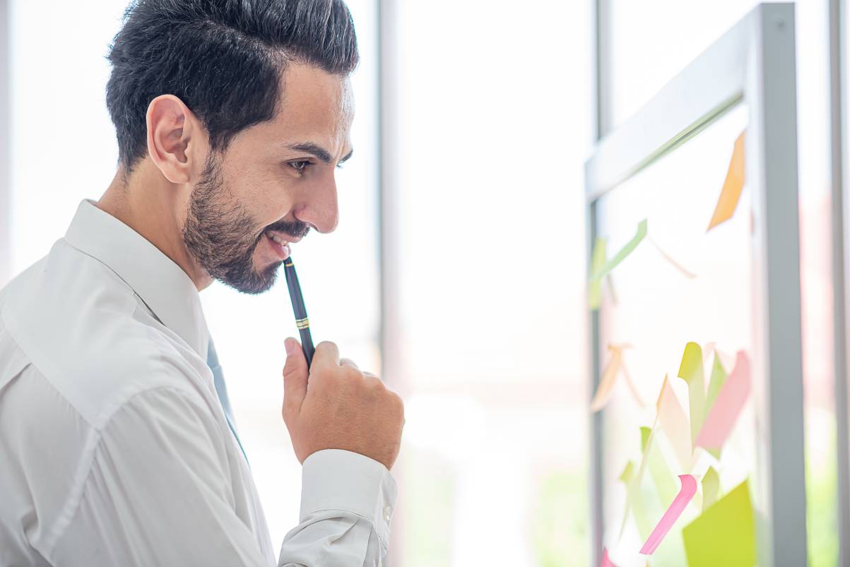 Businessman hold pen to post it for idea analysis and planning