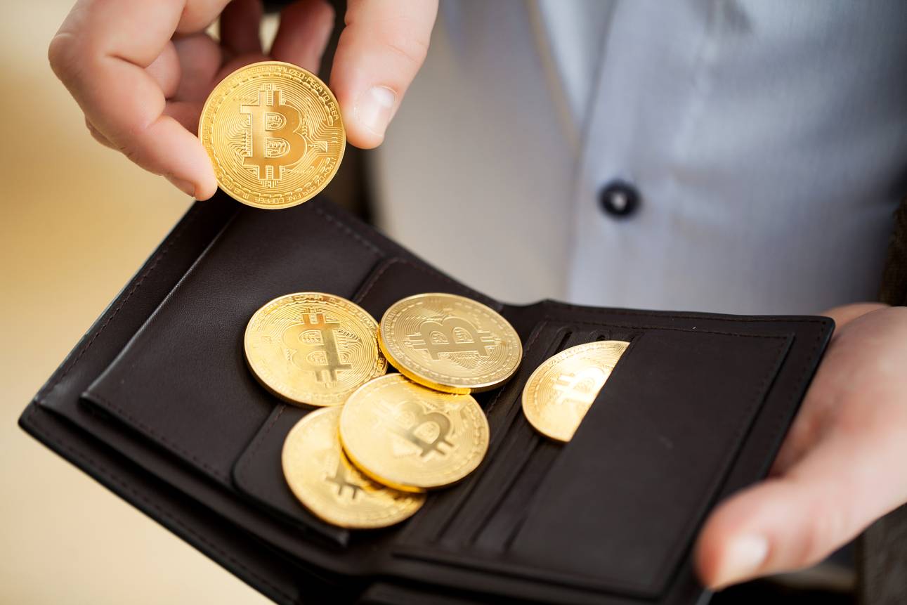 Golden bitcoin coins in man hands