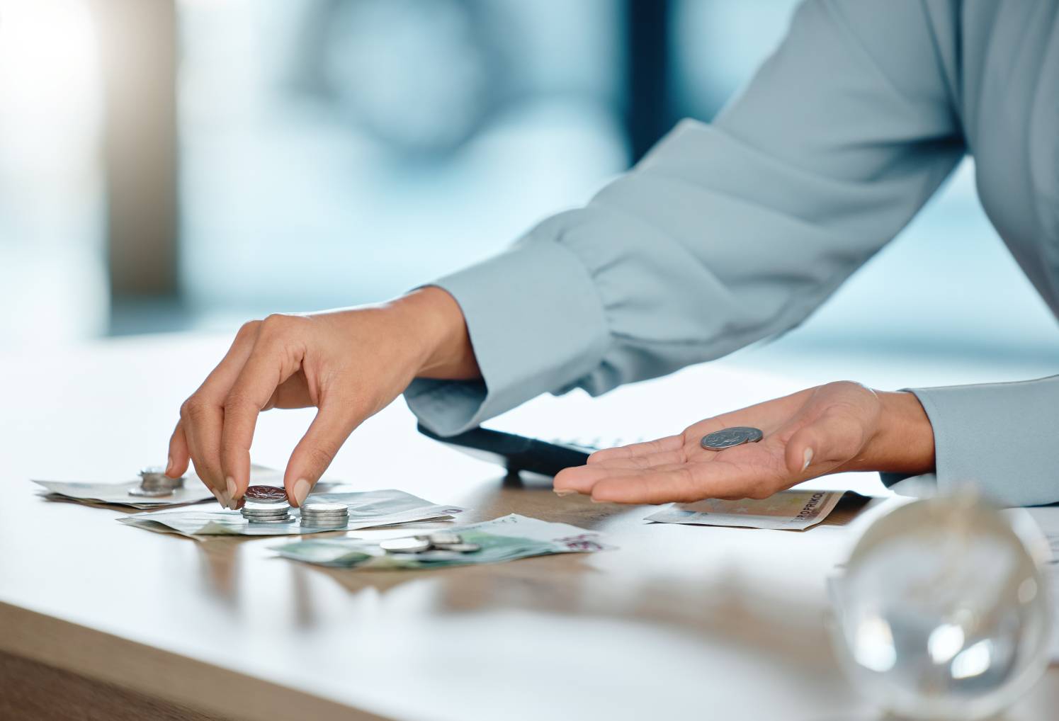 Hands counting and saving money to create a budget for a wise financial investment with a bank.