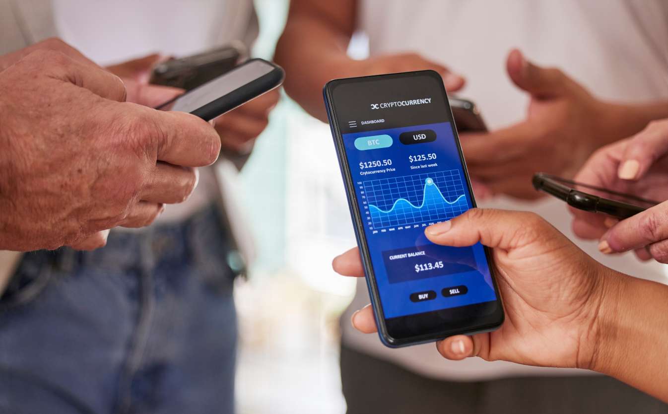 Phone screen, cryptocurrency and trading with people hands, fintech and investment with stock market
