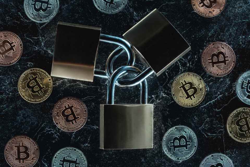 Top view of arranged locks and various bitcoins on dark marble surface