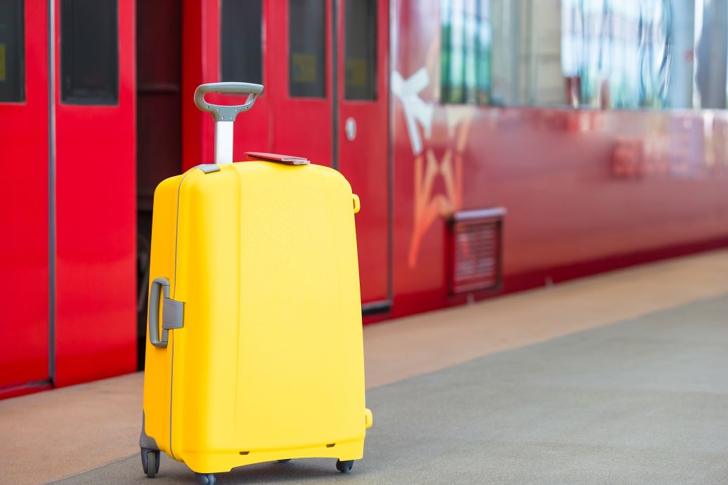 Two passports on yellow luggage at train station